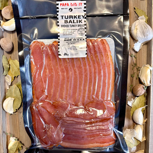 Packaged smoked turkey bacon with a label on a wooden background