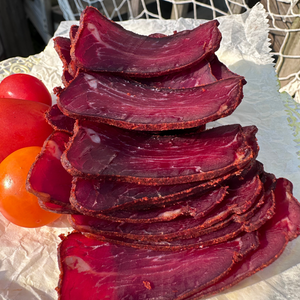 Close-up of sliced basturma with tomatoes in natural light