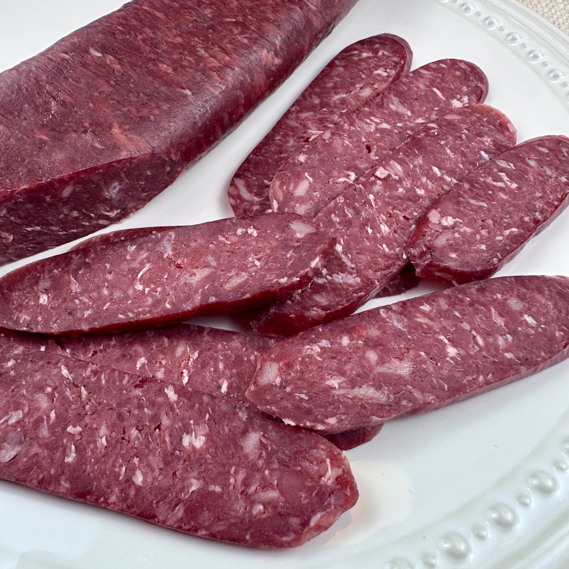 Beef sudjuk sausage slices showing marbled texture