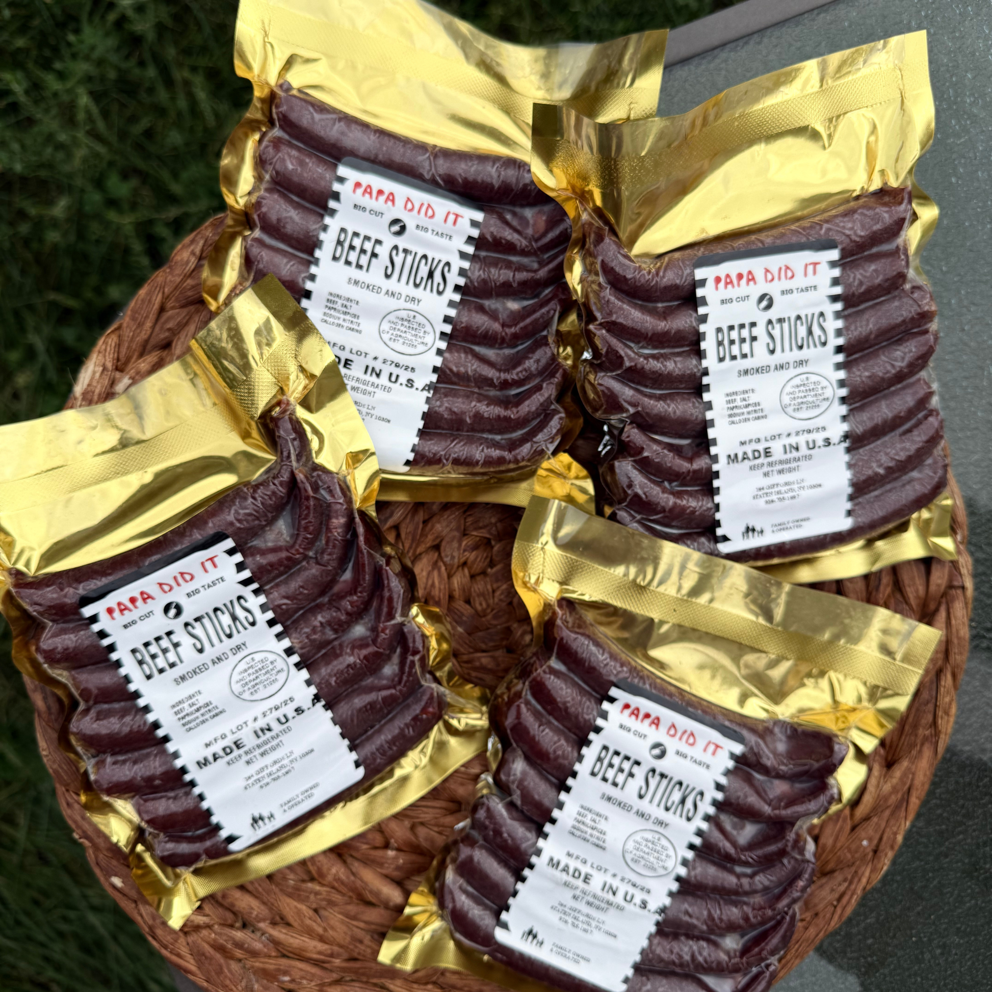 Papa Did It beef sticks in gold vacuum packaging arranged in a basket outdoors