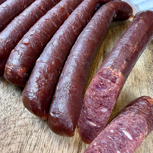 Papa Did It hickory-smoked beef sticks sliced to reveal the tender, dry-cured interior — premium handcrafted beef snack with natural smoky flavor and marbled texture