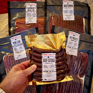 Papa Did It Meat Gift Box — collection of 5 USDA-approved, hickory-smoked meats in vacuum-sealed packaging: beef prosciutto, basturma, pork loin, turkey balyk, and beef sticks.