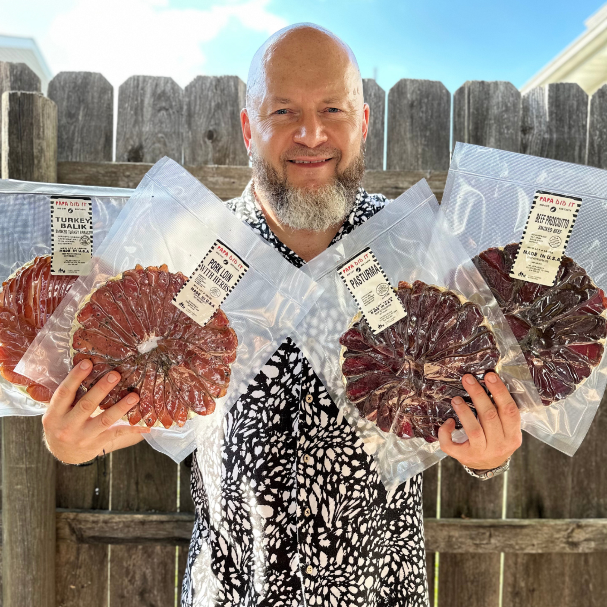 Man holding vacuum-packed sliced pastirma and smoked meats from Papa Did It