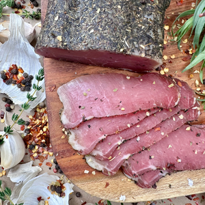 Close-up of smoked pork loin with herbs, sliced on cutting board
