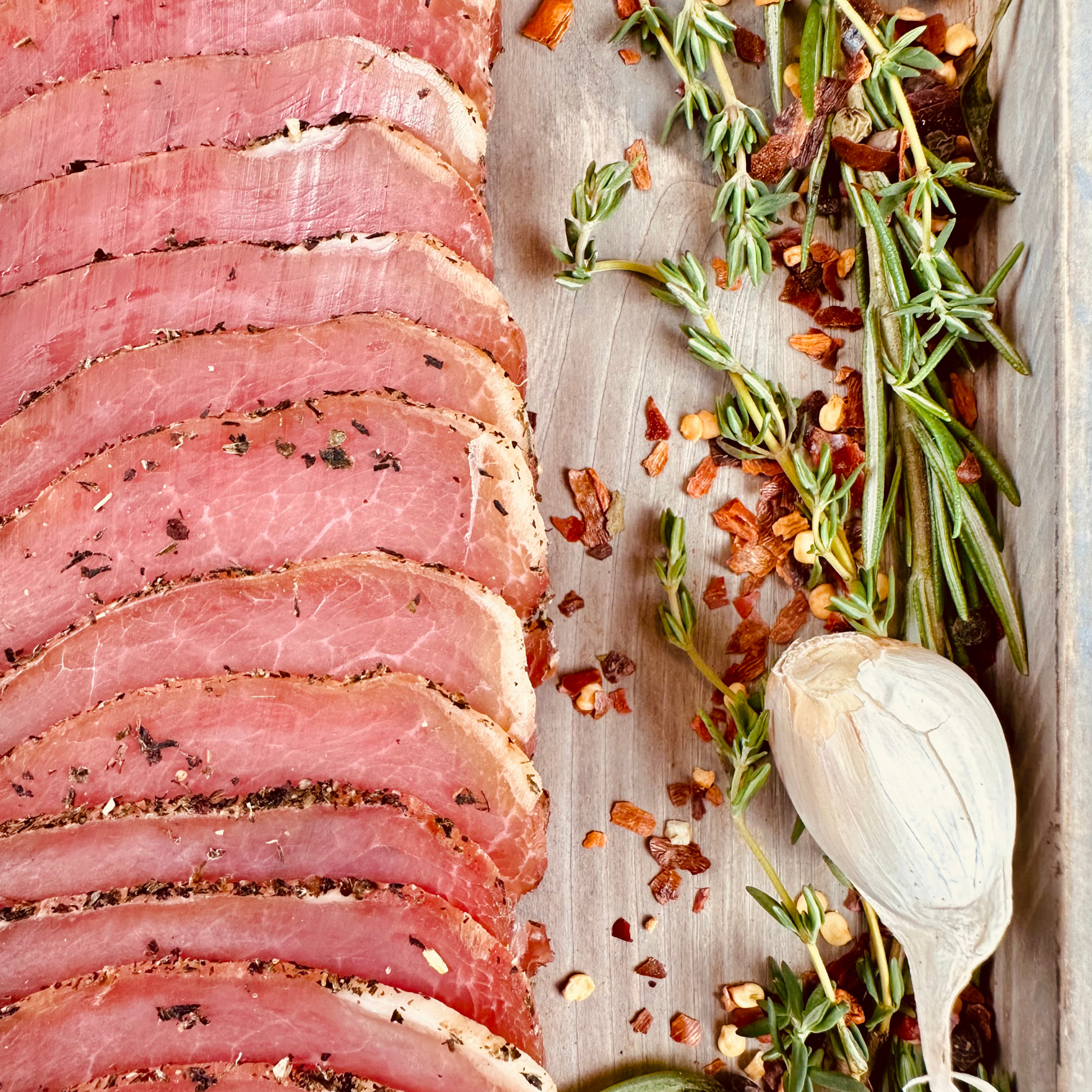 Detail of pork loin slices with rosemary, thyme, and garlic