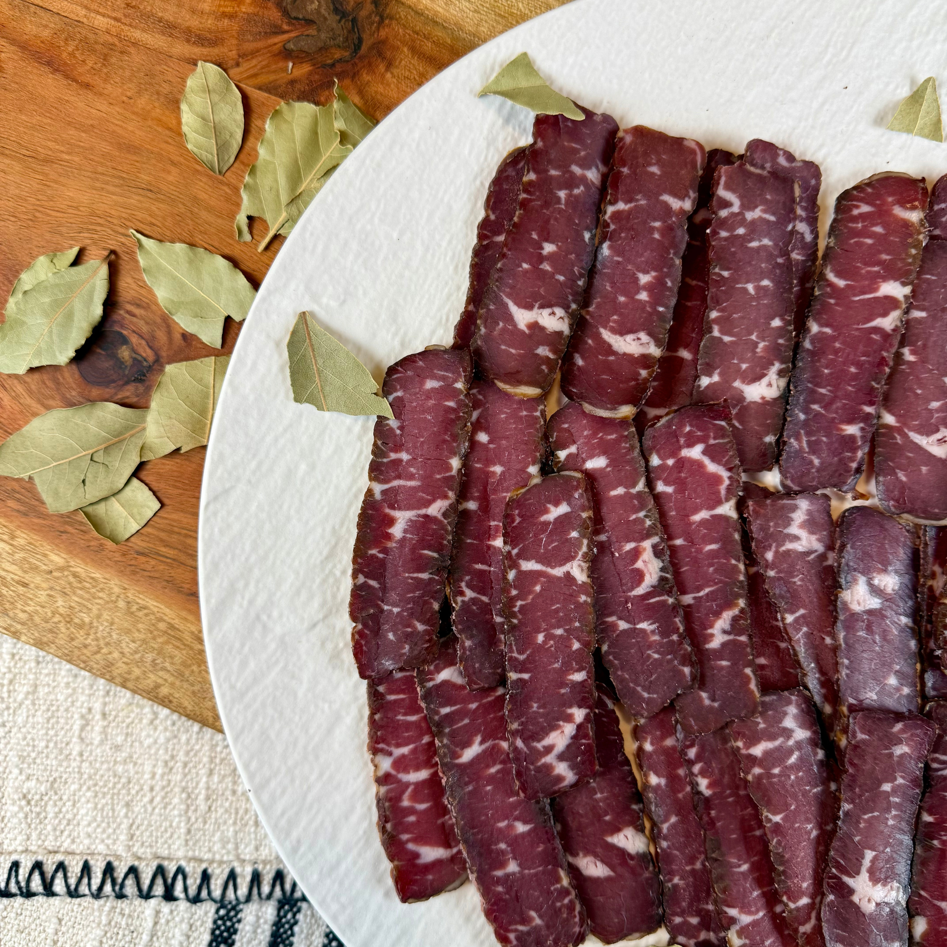 Suho Meso Balkan style dry cured beef sliced thin on white plate